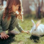 Kaninchen und Mädchen im Garten