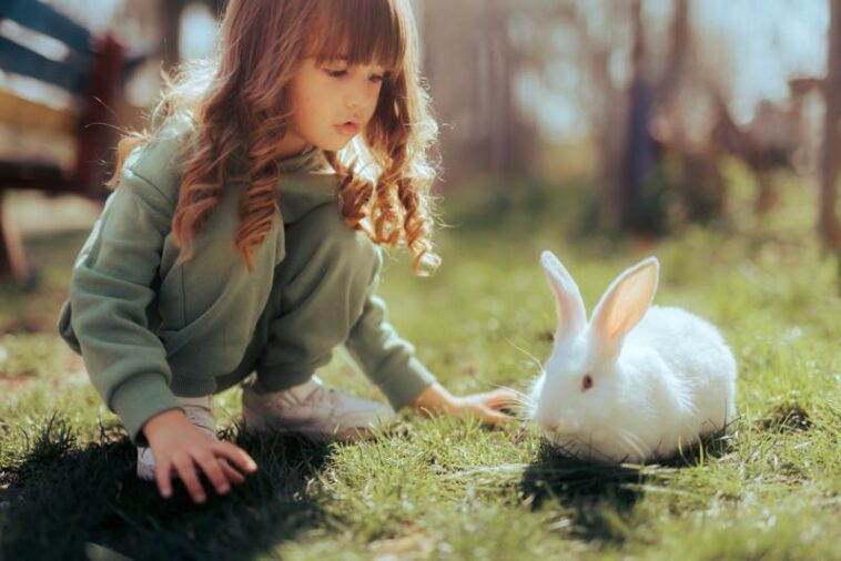 Kaninchen und Mädchen im Garten